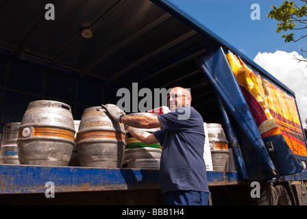 Un membre du personnel de la brasserie Adnams le déchargement et la livraison ale et bière dans un pub de l'arrière d'un camion dans le Suffolk, Royaume-Uni Banque D'Images
