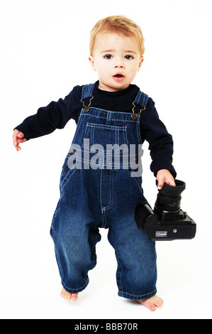 Jeune bébé sur fond blanc avec l'appareil photo et la marche Banque D'Images