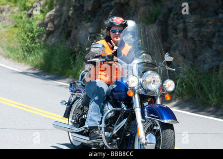 Une femme rider avec passager sur une moto Harley-Davidson moto à Hawks Nest, New York USA. Banque D'Images