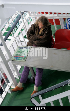 Homme endormi sur un ferry Banque D'Images