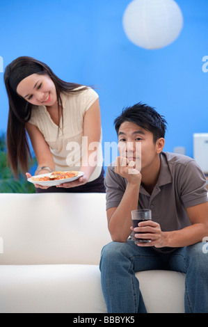 Jeune femme homme offrant une assiette de nourriture Banque D'Images