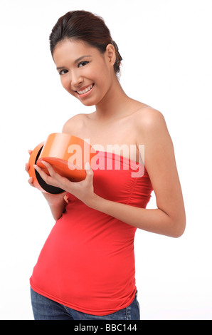 Young woman smiling at camera, holding box Banque D'Images