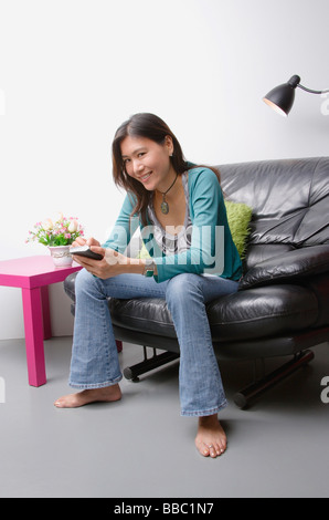 Femme assise sur la table à l'aide d'organisateur Banque D'Images