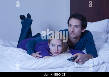 Couple in bed watching TV Banque D'Images