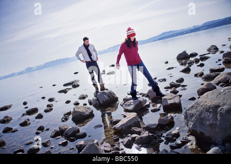 Couple walking on rocks near Lake Banque D'Images