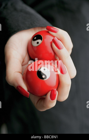 Woman holding Yin Yang balls Banque D'Images