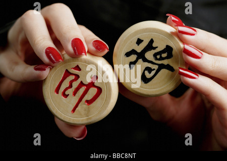 Womans mains tenant pièces des échecs chinois Banque D'Images