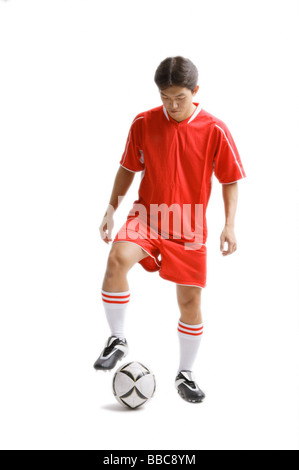 Jeune homme en uniforme de football avec ballon de soccer Banque D'Images