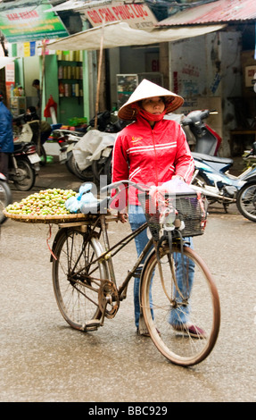 Vender de rue poussant son vélo vente locale plum dans le vieux quartier, Hanoi, Vietnam. Banque D'Images