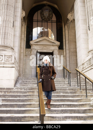 Femme sur les marches de la bibliothèque de New York Banque D'Images