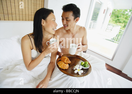 Couple having breakfast in bed Banque D'Images