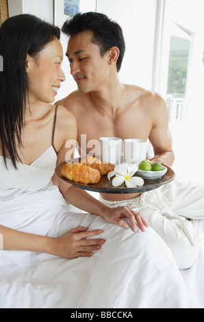 Couple having breakfast in bed, à l'un l'autre Banque D'Images