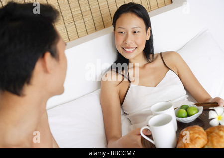 Couple in bed having breakfast Banque D'Images