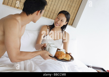 Couple having breakfast in bed Banque D'Images