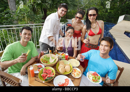 Les jeunes adultes sur patio, smiling at camera Banque D'Images