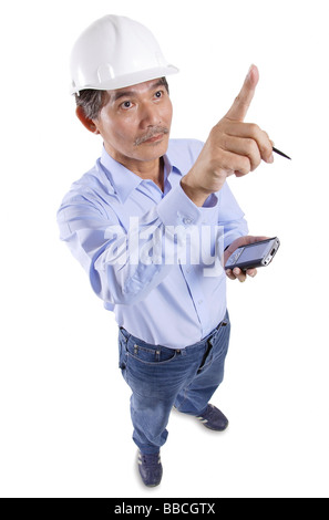 Man wearing hat construction, holding PDA, pointant Banque D'Images