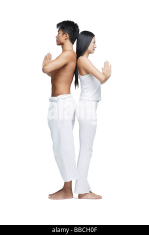 Couple doing yoga position, debout dos à dos Banque D'Images