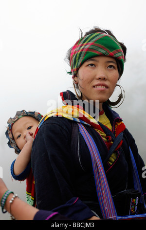 Femme Hmong noir à Sapa avec bébé sur un jour brumeux Banque D'Images