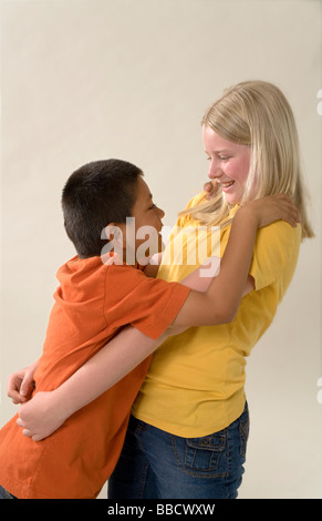 Adoption young Caucasian girl with a adopté hispaniques mexicains plus jeune frère s'amusant multiculturelle diversifiée multi multiethnique MR © Myrleen Pearson Banque D'Images