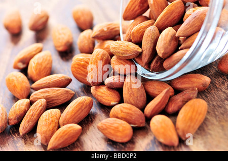 Amandes brutes s'échappant du petit bol en verre Banque D'Images