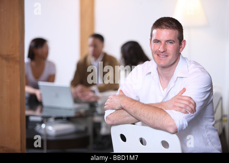 Portrait of Caucasian man en premier plan avec des collègues de travail en arrière-plan Banque D'Images