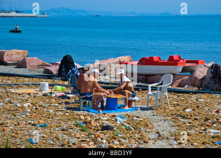 Personnes jouant un jeu sur une plage sale dans Durres Albanie Europe Banque D'Images