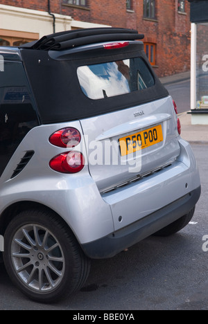 Une petite voiture économique eco friendly smart dans un Royaume-Uni street montrant la plaque numéro personnalisé humour lecture poo Banque D'Images