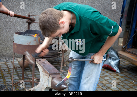 Un maréchal-ferrant démontrant l'art de faire un fer à cheval. Banque D'Images