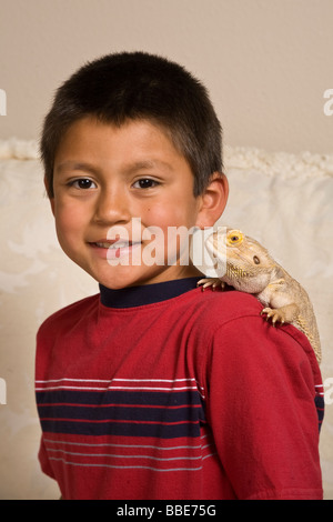 Portrait jeune 7-9 ans ans ethnicité hispanique garçon dragon barbu sur l'épaule à la caméra à l'arrière-plan gros plan découpe découpe Banque D'Images