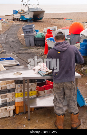 Un pêcheur local préparation des poissons capturés plus tôt, en vente à sa boutique store stall sur la plage à Aldeburgh, Suffolk, UK Banque D'Images