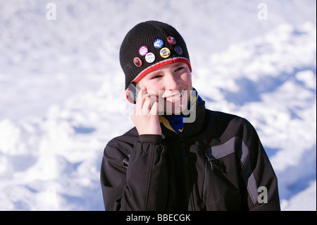 Boy Talking on Cell Phone Outdoors in Winter, Salzburger Land, Autriche Banque D'Images