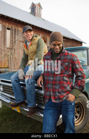 Deux jeunes hommes par un vieux camion sur une ferme à Hillsboro, Oregon, USA Banque D'Images