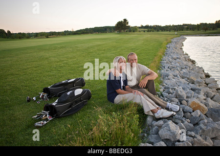 Couple Sitting par Étang sur terrain de golf, Burlington, Ontario, Canada Banque D'Images