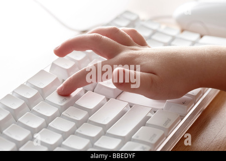 Enfant en appuyant sur la touche de suppression sur ordinateur Banque D'Images