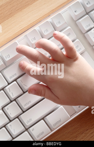 Enfant en appuyant sur la touche de suppression sur ordinateur Banque D'Images