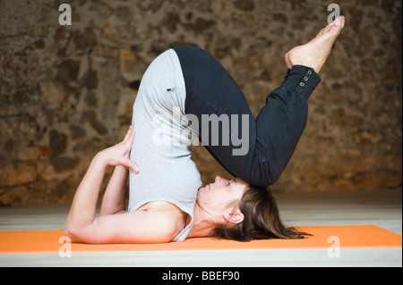 Woman in Yoga Position épaule faisant Banque D'Images