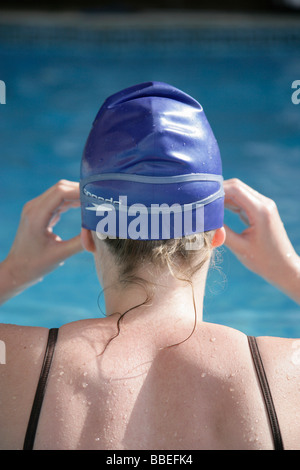 Femme par Piscine avec bonnet et lunettes Banque D'Images