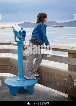 Garçon à la recherche sur l'eau à partir de la jetée, San Francisco, California, USA Banque D'Images