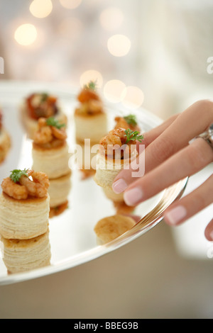 Femme de prendre une pâte de crevettes Pasty hors d'oeuvre à partir d'un bac Banque D'Images