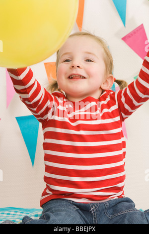 Petite fille jouant avec un ballon à une fête Banque D'Images