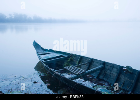 Canoë en matin de brume à Sras Srang, Angkor, Cambodge Banque D'Images