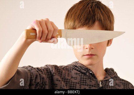 Boy Holding Knife en face des yeux Banque D'Images