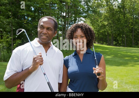 Portrait de couple holding Clubs de Golf Banque D'Images