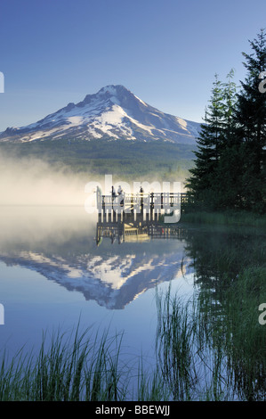 Casting pêcheurs à partir d'un dock sur un matin brumeux, Trillium Lake, Oregon Banque D'Images