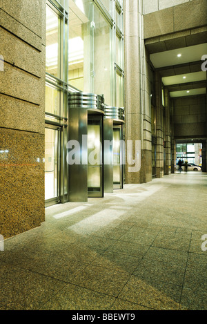 Des portes tournantes à l'entrée de l'immeuble de grande hauteur Banque D'Images