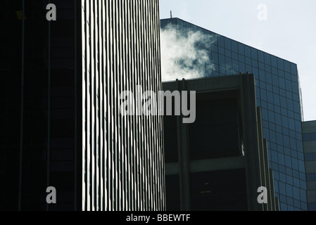 Des tours d'immeubles de bureaux côte à côte, de la vapeur s'échapper de la vapeur, sur le toit, low angle view Banque D'Images