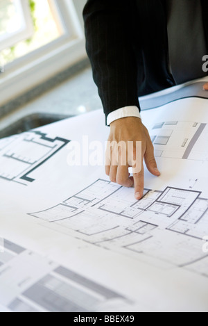 Homme pointant à l'area sur blueprint, close-up Banque D'Images