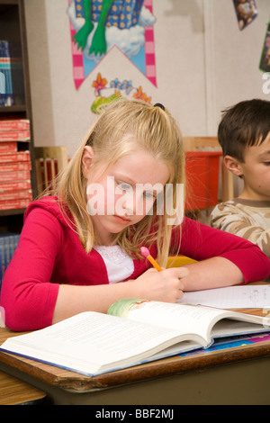 Jeune fille enfant enfants 8-9 ans lecture lit studying in classroom United States Monsieur © Myrleen Pearson Banque D'Images