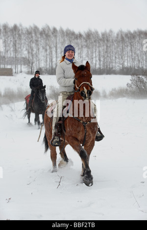 Deux jeunes, les motardes sur cheval Haflinger en hiver Banque D'Images