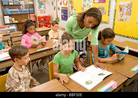 La diversité raciale multi culturel multiculturel la diversité raciale Teacher assisting student 8-10 ans enfant cahier de travail classe bureau d'étude Banque D'Images